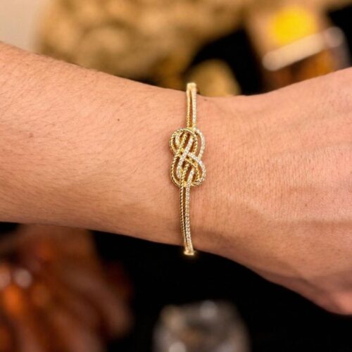 Brazalete oro con diseño de nudo infinito entrelazados con circonita