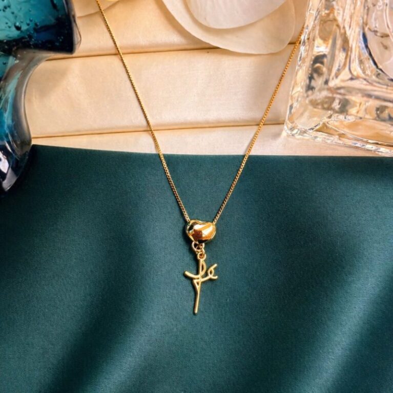 Cadena fina oro con dije de corazón pulido y la palabra Fe colgante