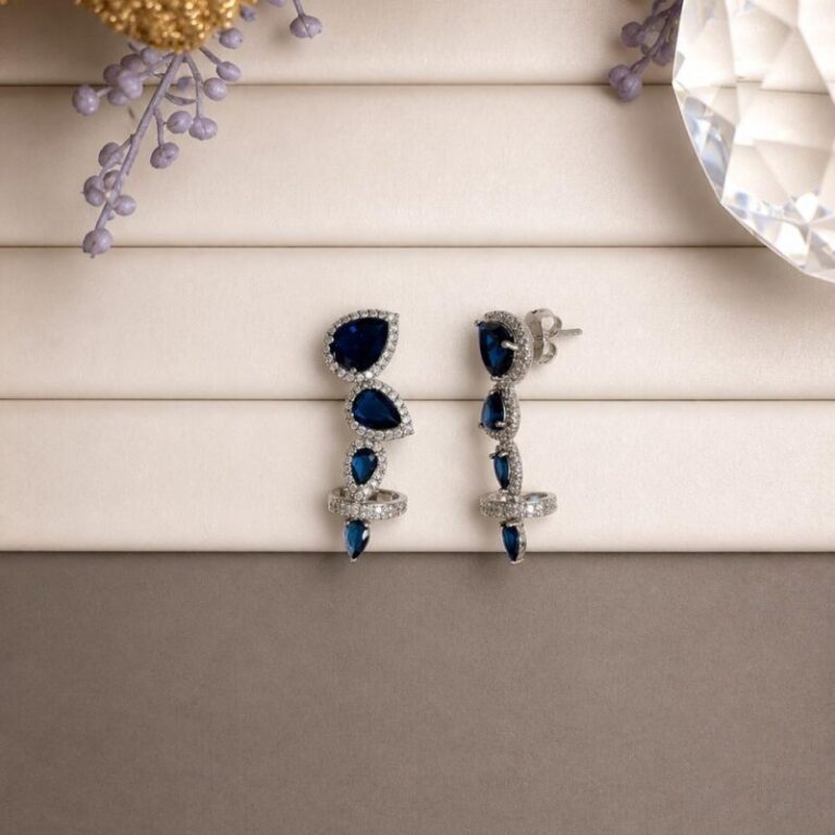 Aro rodio estilo trepadora con 4 circonitas en forma de gotas diferentes tamaños azules con circonitas blancas